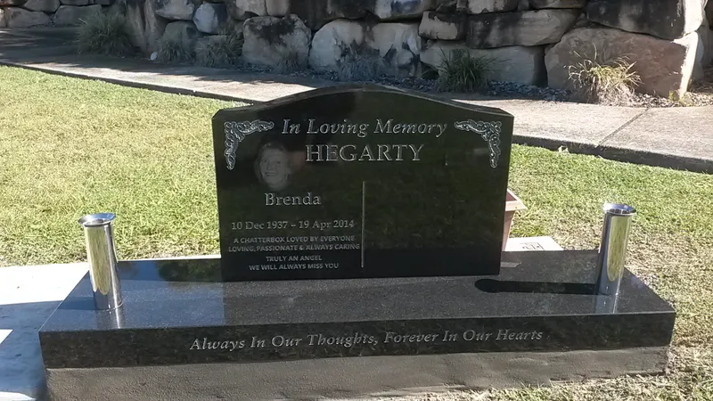 Black granite headstone with stainless steel vases on a granite base