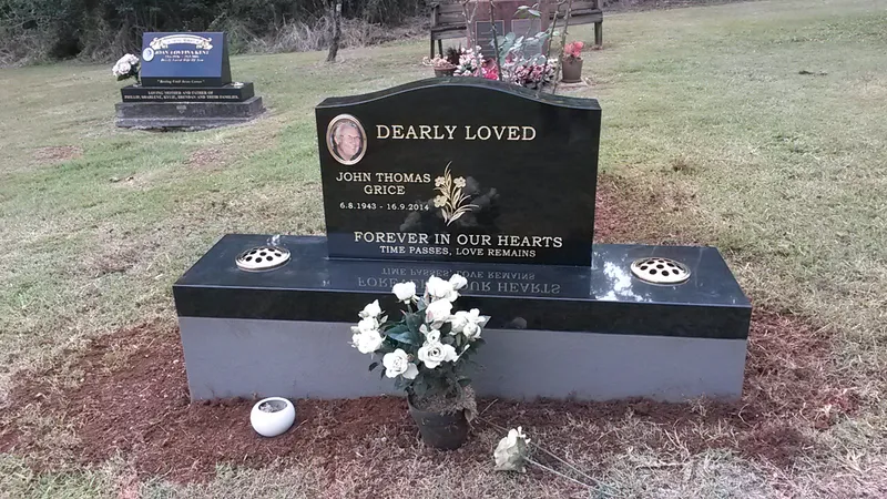 Black granite headstone with a photo plaque and built-in vases