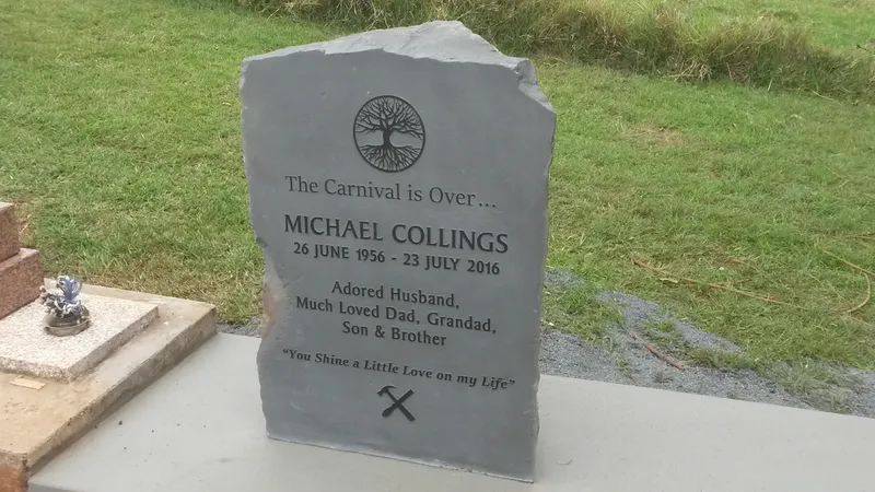 Upright natural grey stone headstone with rock-pitched edges and an engraved tree