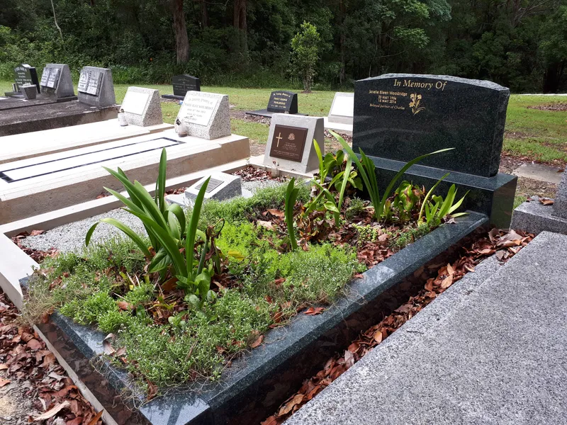 Black granite kerbing and headstone enclosing a planted garden bed