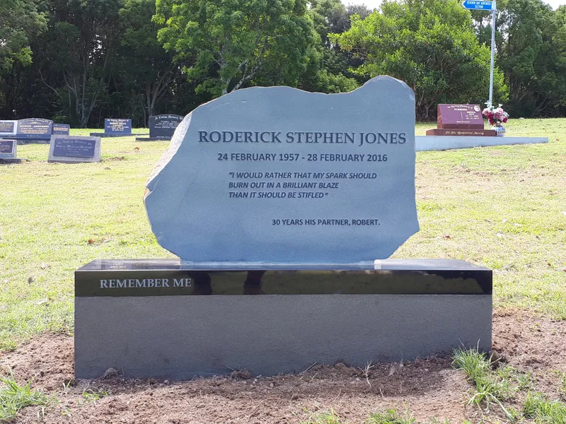 Rustic grey natural stone headstone on a black granite base