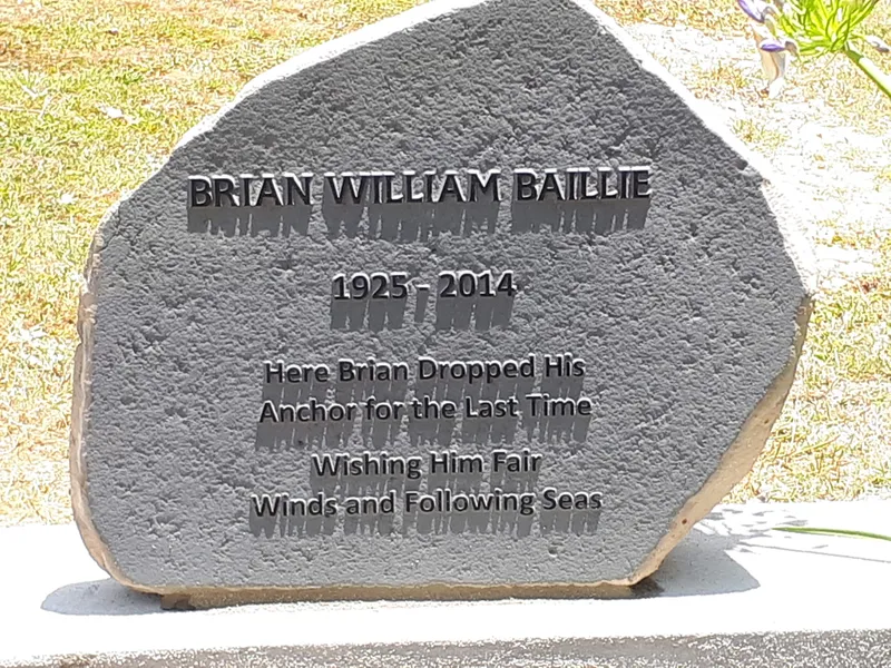 Natural stone memorial with raised lettering on a rustic face