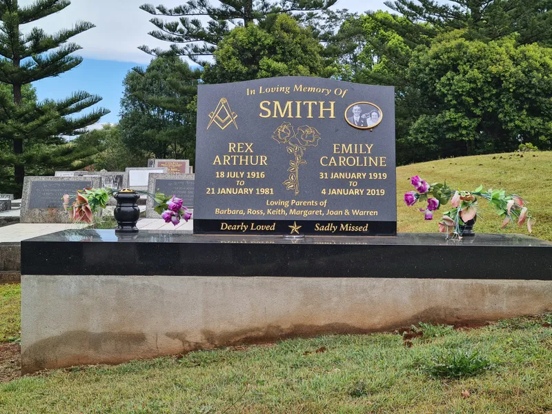 Grey granite double headstone with photo plaques on a black granite base