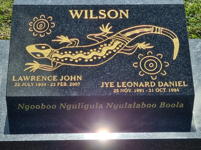 Black granite plaque with a gold-leaf lizard and Aboriginal motifs