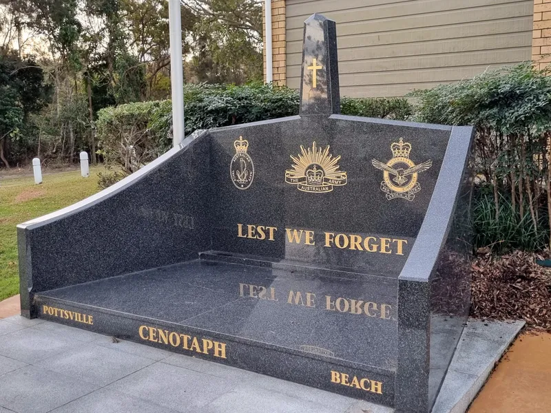 Black granite cenotaph at Pottsville Beach with services emblems and Lest We Forget