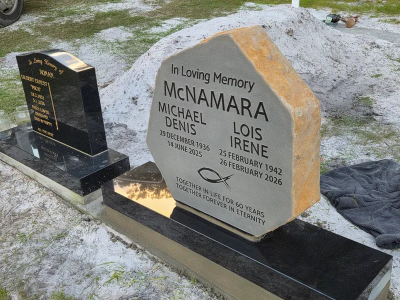 Side view of a shaped double headstone showing its rock-pitched edges