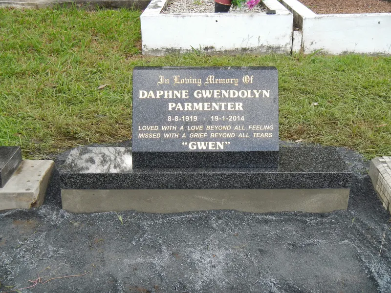 Small black granite headstone with gold lettering on a granite base