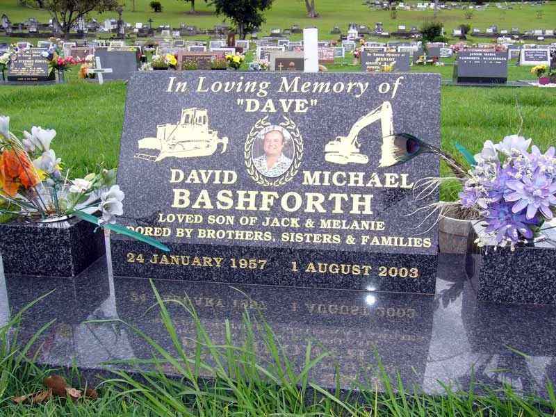 Black granite plaque with a photo plaque and engraved earthmoving machinery