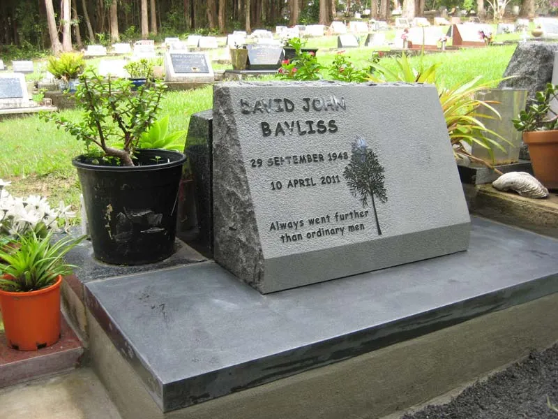 Natural grey stone memorial with an engraved tree on a slate base