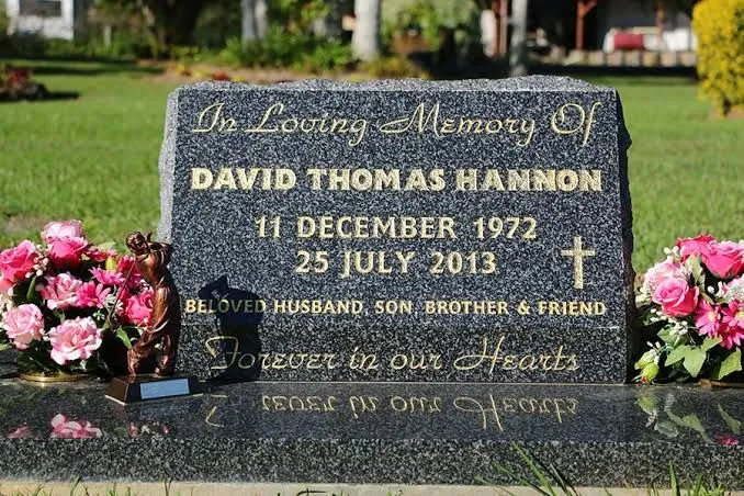 Grey granite sloped desk headstone with rock-pitched edge and gold leaf lettering