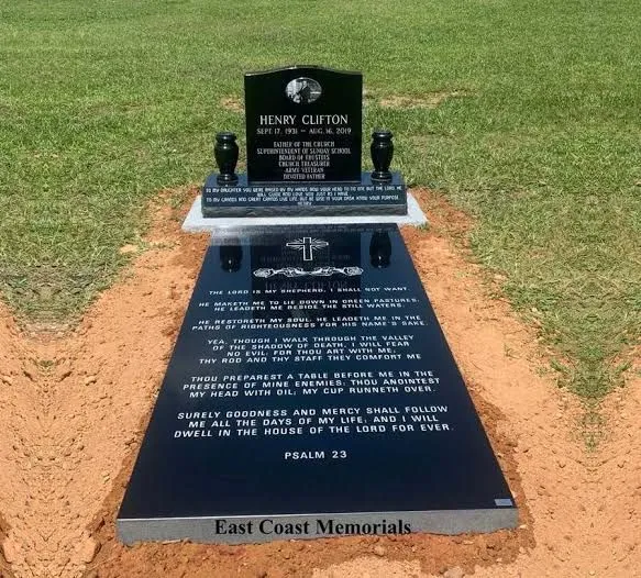 Full black granite monument by East Coast Memorials, with inscribed ledger and vases