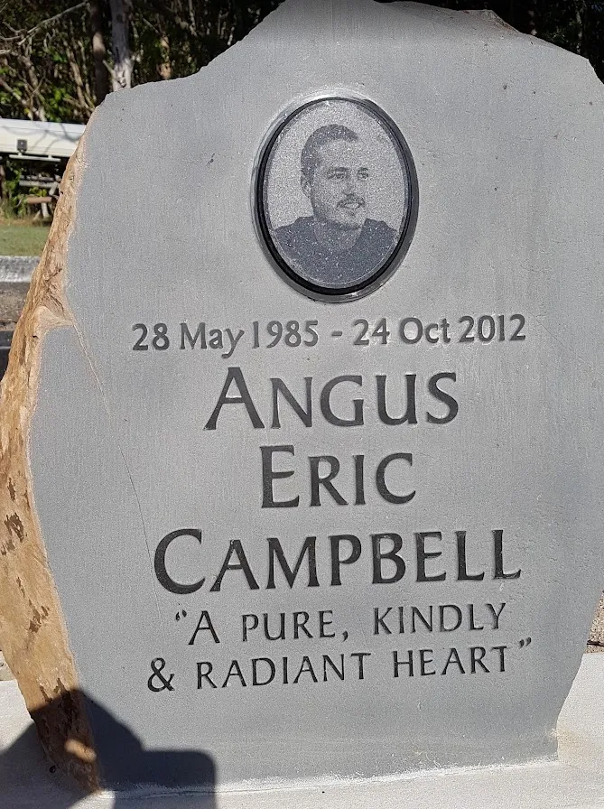 Basalt headstone for Angus Eric Campbell with a raised inscription and a laser-etched portrait on a black granite inset